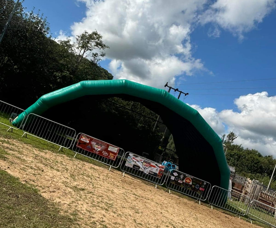 Large stage with green arched roof in field- Event Management- ajc consultancy swansea south wales